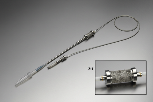 Full stent delivery system on surgical-steel-gray background, diagonal orientation, 2:1 macro inset of stent-loaded balloon section with dual platinum full-ring marker bands at balloon shoulders